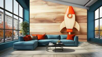 Rocket icon on wooden surface against a plain backdrop symbolizing financial growth and aspirations for success Wall mural