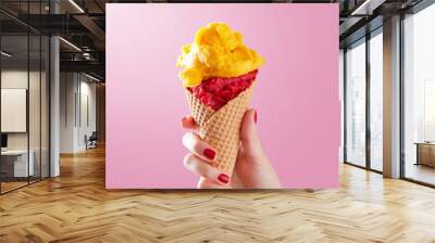 Woman hand holding ice cream cone on a pink background. Copy space Wall mural