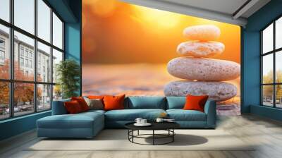 Four smooth stones stacked on wooden surface against sunset copy space Wall mural