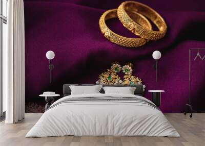 Golden bangles with Gold earrings on a purple saree background  Wall mural