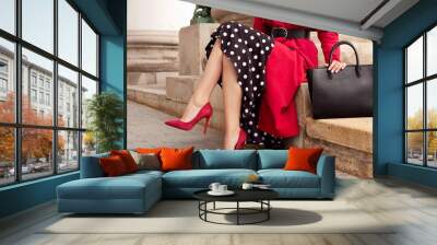 Fashionable woman in red coat, heels, black bag. Outdoor fall and spring outfit Wall mural