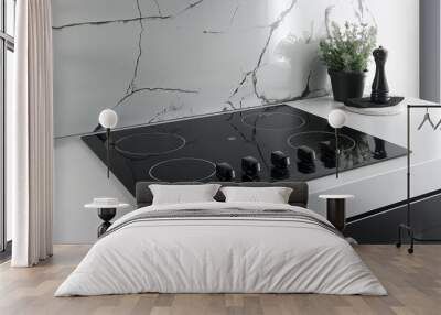 A black glass ceramic hob with three touch control buttons, on top of a white kitchen countertop. The elements are arranged in a straight line is placed at its center point. Generative AI. Wall mural