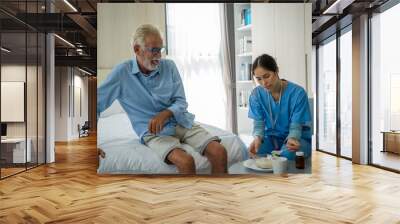 Female nurse are giving food senior man in their home. Wall mural