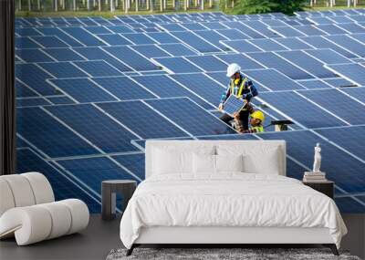 Group of engineer working on checking and maintenance with solar batteries near solar panels at sunny day in solar power plant station. Wall mural