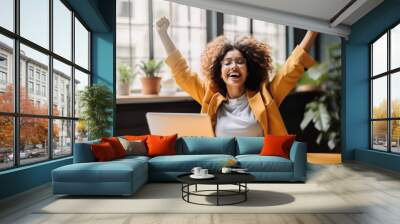 Joyful business woman freelancer entrepreneur smiling and rejoices in victory while sitting at desk after working finishing project at home, Freelancer, Gesturing with her hands rejoicing in victory. Wall mural