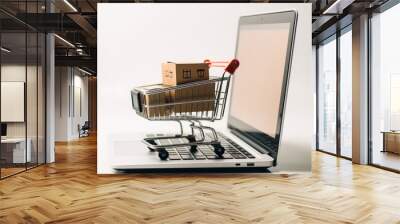 Online shopping and delivery service concept. Paper cartons in a shopping cart on a laptop keyboard, Shipping service for online shopping or ecommerce concept. Wall mural