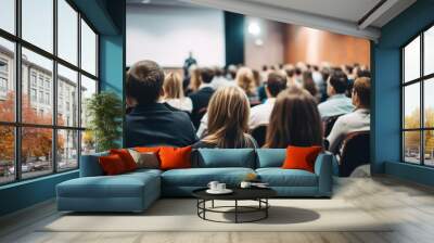 Rear view of people in audience at the conference hall, Speaker giving a talk in conference hall at business event. Wall mural