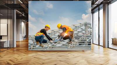 Roofer worker in protective uniform wear and gloves,Using air or pneumatic nail gun and installing concrete roof tile on top of the new roof,Concept of residential building under construction. Wall mural