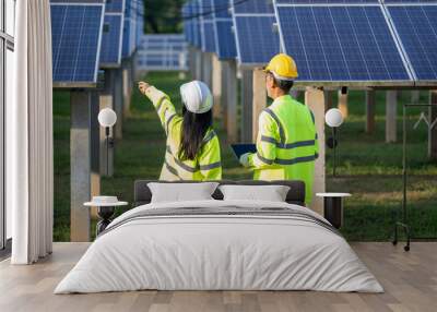 Technicians and engineer in long sleeve shirts reflective vests and hard hats discussing something about solar panel power,Solar power plant to innovation of green energy for life. Wall mural