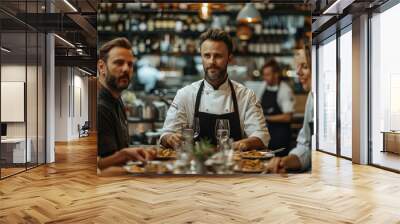 Two chef and a bartender standing at the end of a long table chatting the guests about their meal, customers sat on either side of the table. Generative AI. Wall mural