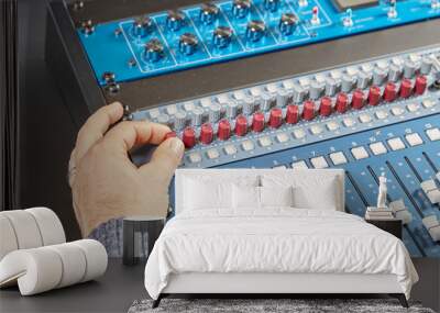 Finger of a man turning the knobs of audio console Wall mural