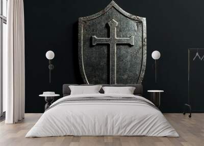 A weathered metal shield with a cross embossed on it, isolated on black. Wall mural