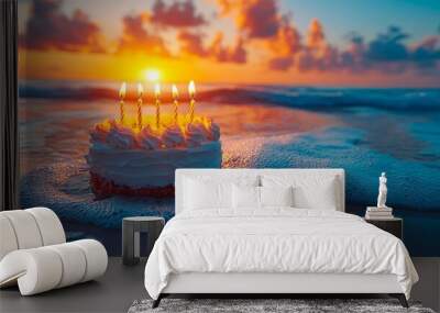 A birthday cake with lit candles sitting on the beach at sunset Wall mural