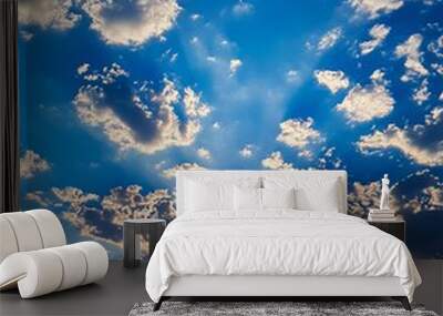 A blue sky with the sun shining through the clouds Wall mural