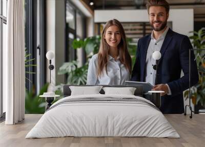 A man and woman standing in an office with a tablet. Wall mural