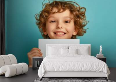 A smiling boy holding a blank card. Wall mural