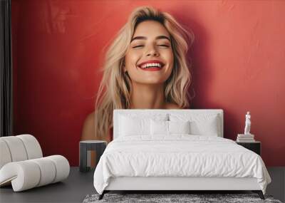 A woman smiling in front of a red wall. Wall mural