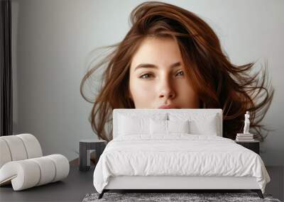 A woman with long brown hair looking at the camera. Wall mural