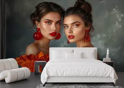 Two beautiful women in green dresses and red earrings. Wall mural