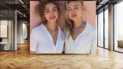 Two young women in white shirts and jeans. Wall mural