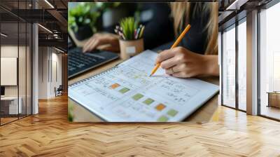 woman hand writing with pencil planning event on notebook. Job schedule, event planning, to do list and reminder, E-learning. Woman working on laptop and taking note on office desk, Generative AI Wall mural