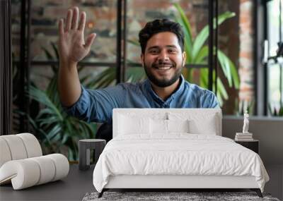 Smiling hispanic employee making hello gesture while keeping hand on table with daybook, pen and tablet. Pleasant bearded man welcoming colleague in meeting room before beginning of, Generative AI Wall mural