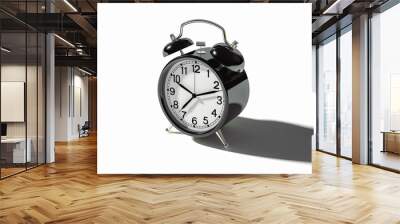 A classic alarm clock with a black case and two glowing hands, set for a specific time, casting a long shadow on a clean white background. Wall mural