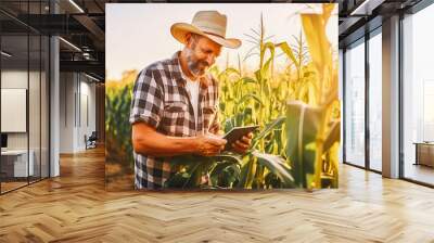 A modern farmer in a corn field using a digital tablet. Farming and agriculture concept. Wall mural