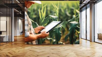 A modern farmer in a corn field using a digital tablet. Farming and agriculture concept. Wall mural