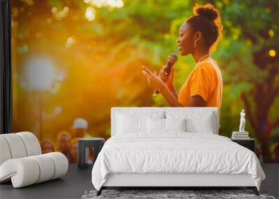 A young Black woman confidently gives a speech in a park at sunset, her message resonating with the crowd. Wall mural