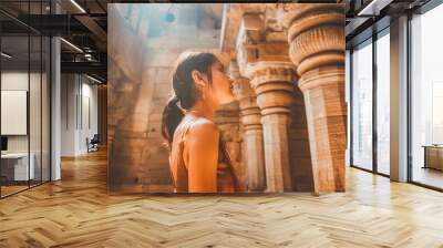 A young Indian woman exploring the architecture of a historic cathedral, captivated by the spiritual significance of the landmark. Wall mural