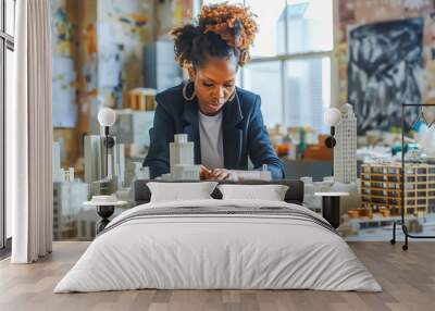 An architect, a Black woman with a focused gaze, creates a miniature city model from recycled materials, envisioning sustainable urban planning. Wall mural