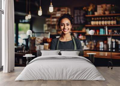 Beautiful young indian female coffee shop owner standing behind counter and smiling, successful business owner in her shop Wall mural