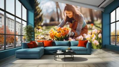 Florist female in beautiful garden in sunny spring, women with small business, colorful flowers on rural farm, botanical garden. Wall mural