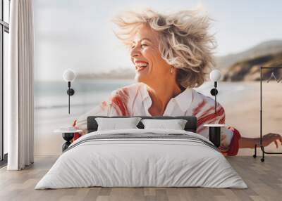 happy dancing mature woman at the beach Wall mural