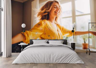 Positive white woman dancing at home. Happiness and well being concept. Wall mural