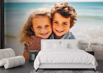 Siblings hugging at the beach on a sunny day on vacation. Cute smiling siblings hugging on beach Wall mural