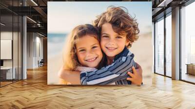 Siblings hugging at the beach on a sunny day on vacation. Cute smiling siblings hugging on beach Wall mural