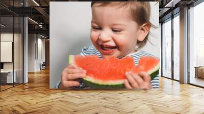 The baby is trying a new taste of solid food. Eating healthy food from the beginning is important. Young child doesn't want to eat vegetable and fruit. Wall mural