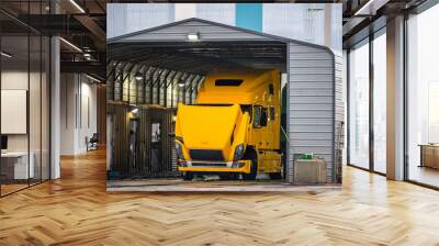 Big rig bright yellow semi truck with open hood washes in a trucks car wash in an industrial zone Wall mural