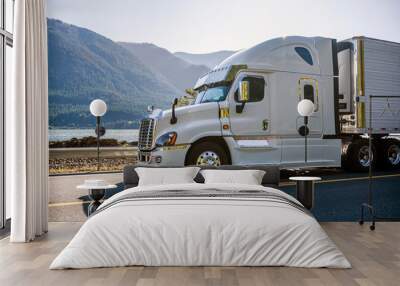 Big rig white semi truck with chrome accessories driving with reefer semi trailer for delivery commercial cargo on the road along the river Wall mural