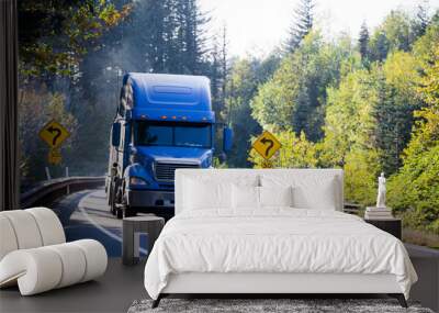 Blue semi truck and flat bed trailer on sunny green and gold autumn trees Wall mural