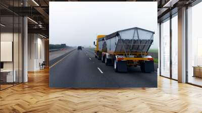 Chic new yellow truck with two bulk trailers on straight as arrow highway in fog Wall mural