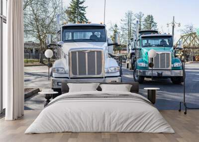 Day cab big rig semi-truck tractors towing another semi-trucks take a break standing on the industrial parking lot Wall mural