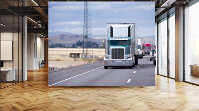 Green classic big rig semi truck reefer unit on traffic road Wall mural