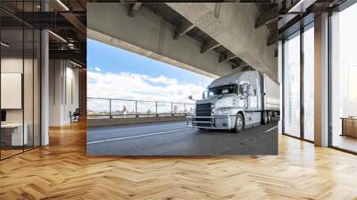 Light gray big rig semi truck transporting cargo in refrigerator semi trailer driving on the two level transportation Fremont bridge in Portland Wall mural