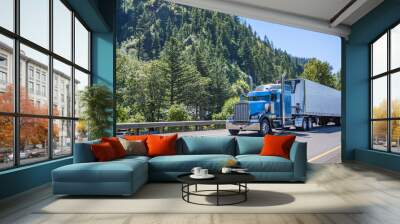 Powerful blue big rig long haul semi truck transporting frozen cargo in reefer semi trailer running on the wide highway road in Columbia Gorge area Wall mural