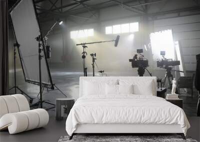 Profesional video studio.Behind-the-scenes of a video shooting.Behind the shooting production silhouette of camera and equipment in studio.Selective focus. Wall mural