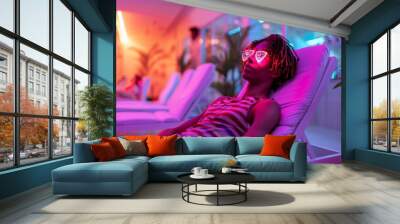 man relaxes in a chair, donning stylish sunglasses, soaking in the suns rays in a solarium. Wall mural