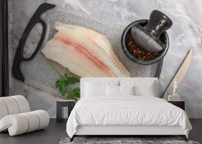 Fillet of raw pangasius fish with parsley on cutting board Wall mural